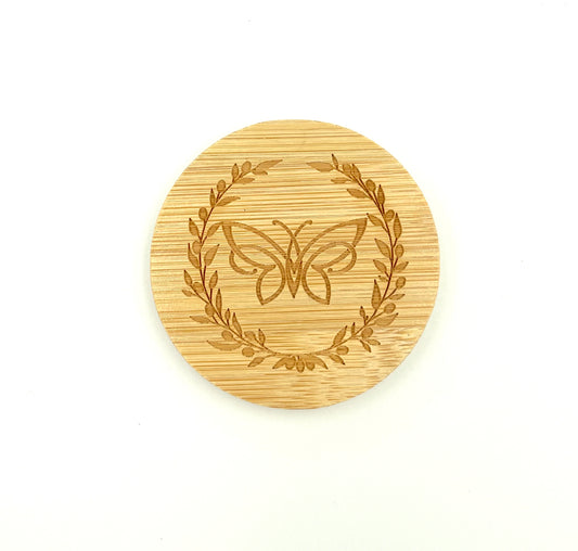 Bamboo mirror with engraved butterfly and olive wreath design on a white background